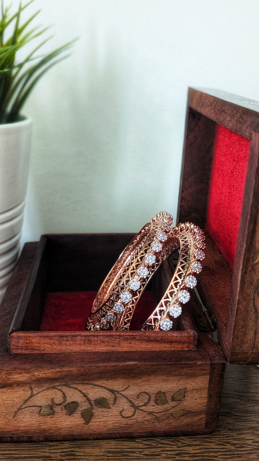 Rose gold bangles with diamond accents in a wooden box on a wooden surface. Pick-up in Ajax Ontario. Worldwide shipping available. Perfect for wedding, festival jewelry, indian Jewelry, kids jewelry, kundan jewelry, gifting, costume jewelry, fashion jewelry, Eid, onam, Diwali, karwachauth, navratri. Free shipping available. Jewelry for women. Indian jewelry in ajax durham region. Bollywood style jewelry.