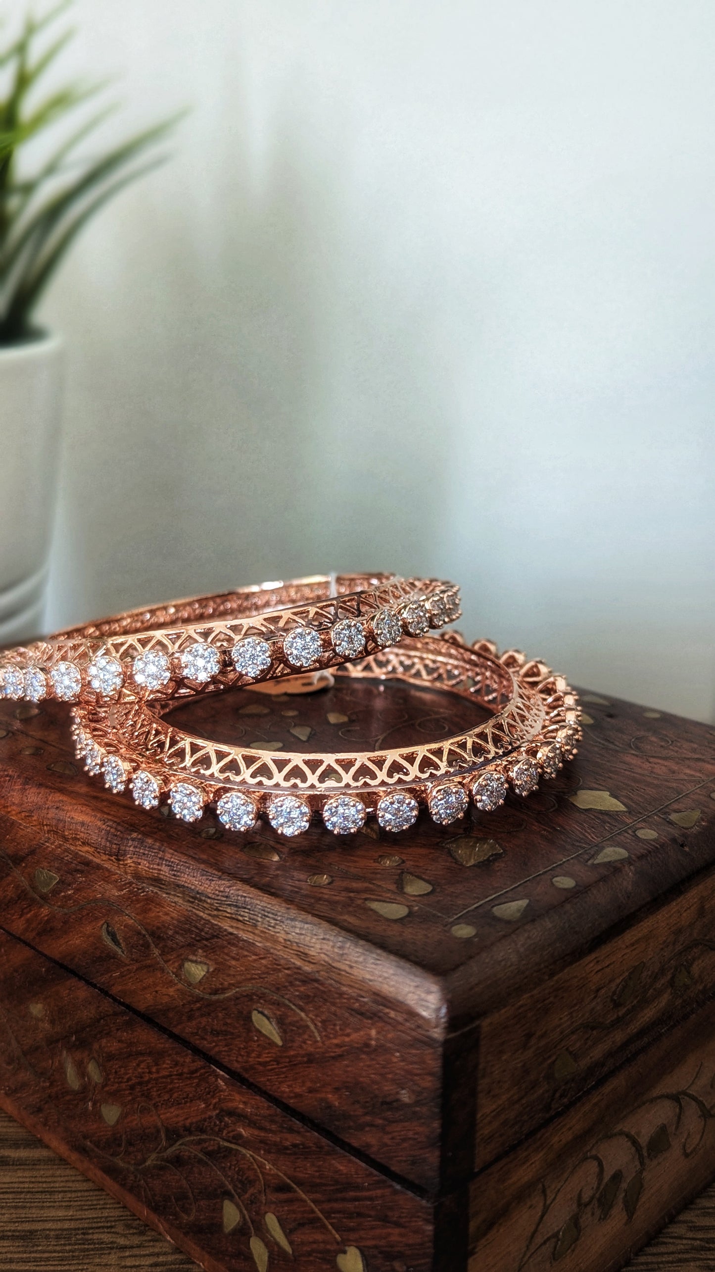 Rose gold bangles with diamond accents in a wooden box on a wooden surface. Pick-up in Ajax Ontario. Worldwide shipping available. Perfect for wedding, festival jewelry, indian Jewelry, kids jewelry, kundan jewelry, gifting, costume jewelry, fashion jewelry, Eid, onam, Diwali, karwachauth, navratri. Free shipping available. Jewelry for women. Indian jewelry in ajax durham region. Bollywood style jewelry.