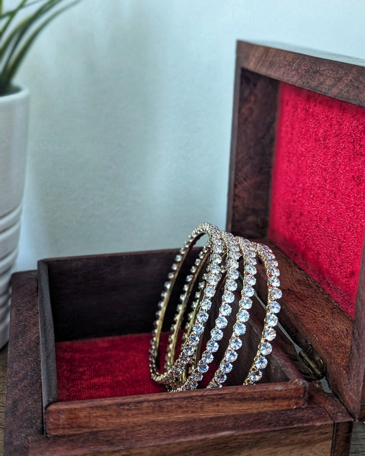 A set of four slim, gold-plated imitation bangles with a minimalist design and subtle sparkle. The bangles are stacked together on a soft fabric background, showcasing an everyday elegant style. Pick-up in Ajax Ontario. Worldwide shipping available. Perfect for wedding, festival jewelry, indian Jewelry, kids jewelry, kundan jewelry, gifting, costume jewelry, fashion jewelry, Eid, onam, Diwali, karwachauth, navratri. Free shipping available