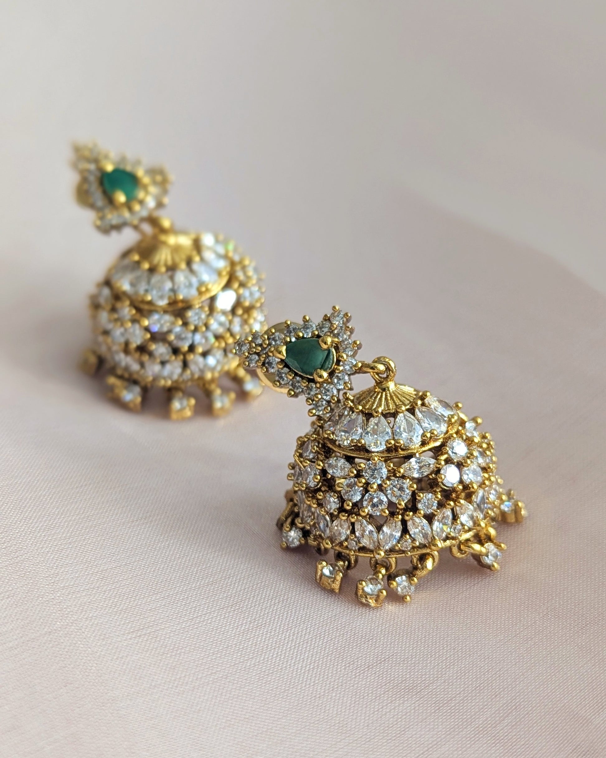 Gold and green gemstone earrings held by a hand on a light background looks like real gold. Pick-up in Ajax Ontario. Worldwide shipping available. Perfect for wedding, festival jewelry, indian Jewelry, kids jewelry, kundan jewelry, gifting, costume jewelry, fashion jewelry, Eid, onam, Diwali, karwachauth, navratri. Free shipping available. Jewelry for women. Indian jewelry in ajax durham region. Bollywood style jewelry.