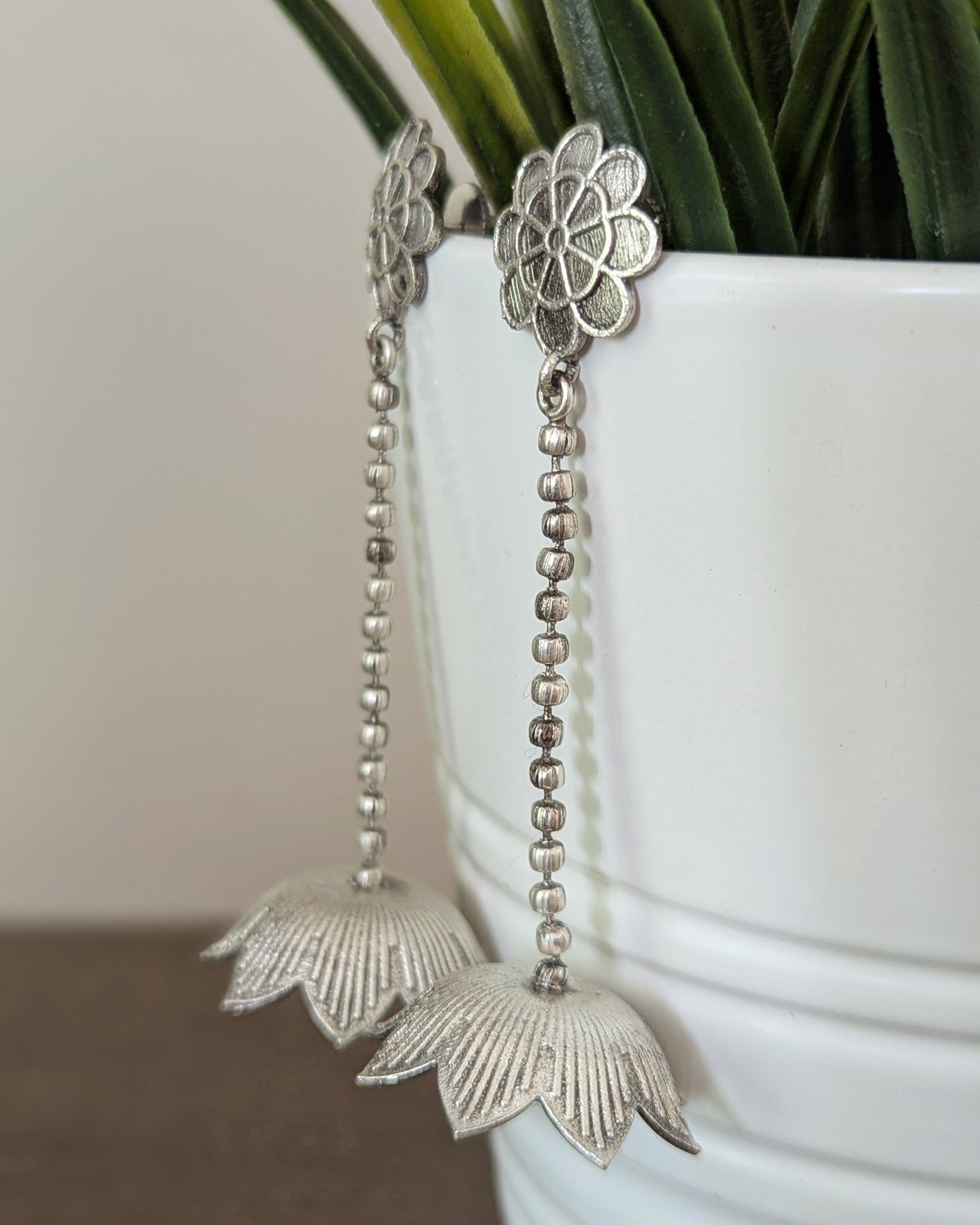 Silver earrings with intricate lotus design hanging by a chain. Pick-up in Ajax Ontario. Worldwide shipping available. Perfect for wedding, festival jewelry, indian Jewelry, kids jewelry, kundan jewelry, gifting, costume jewelry, fashion jewelry, Eid, onam, Diwali, karwachauth, navratri. Free shipping available. Jewelry for women. Indian jewelry in ajax durham region.