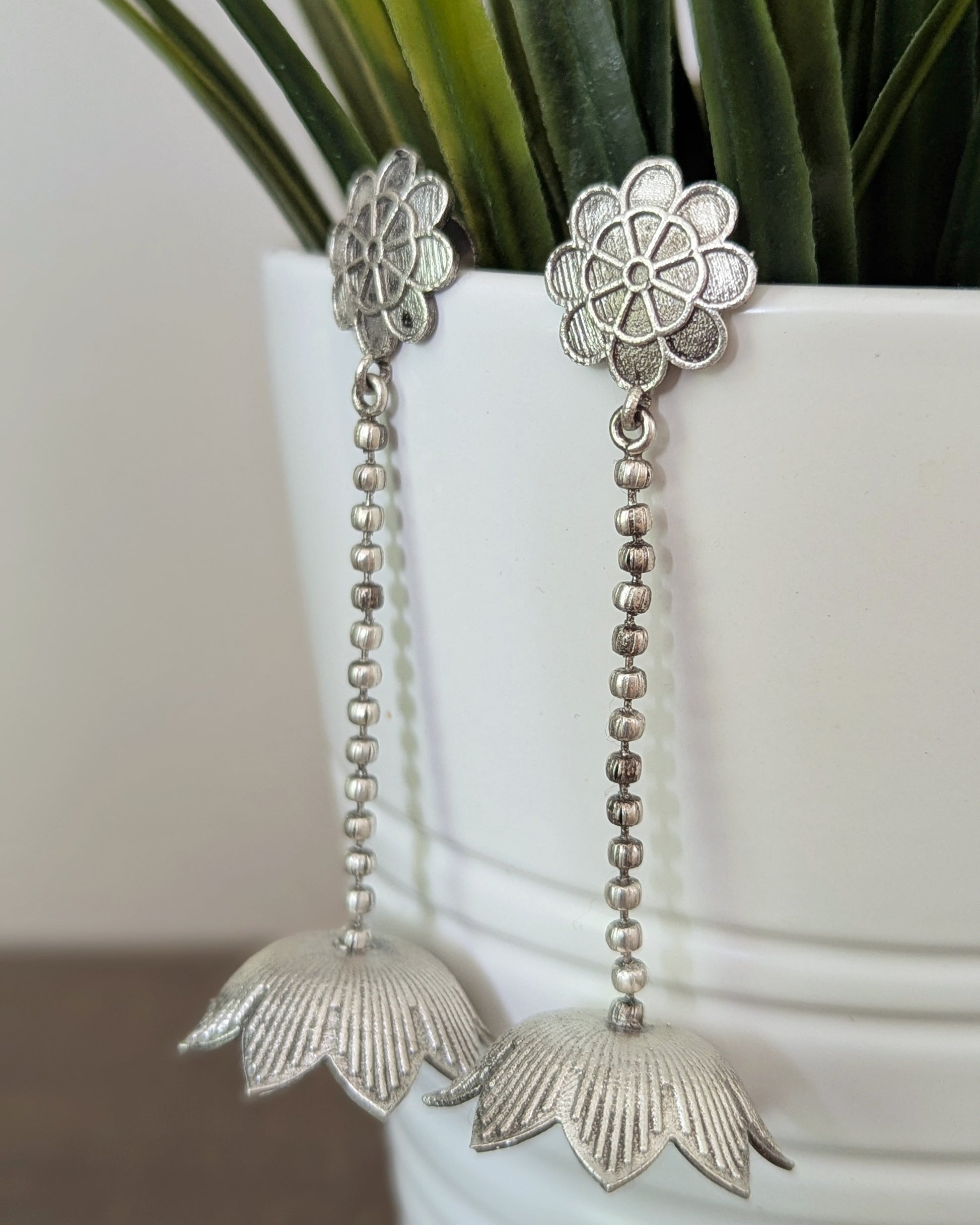 Silver earrings with intricate lotus design hanging by a chain. Pick-up in Ajax Ontario. Worldwide shipping available. Perfect for wedding, festival jewelry, indian Jewelry, kids jewelry, kundan jewelry, gifting, costume jewelry, fashion jewelry, Eid, onam, Diwali, karwachauth, navratri. Free shipping available. Jewelry for women. Indian jewelry in ajax durham region.