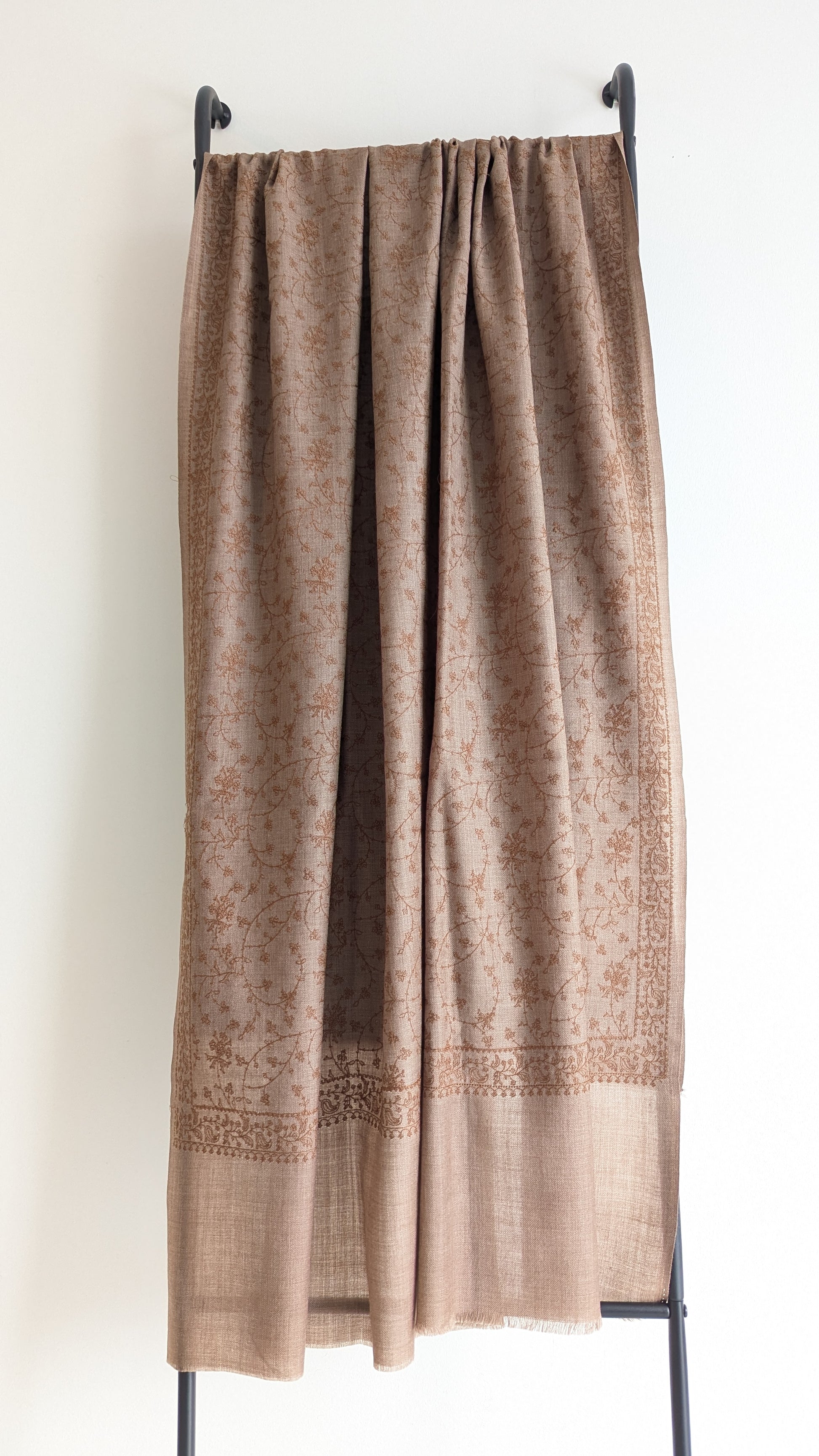 A brown woolen shawl with intricate hand embroidery.