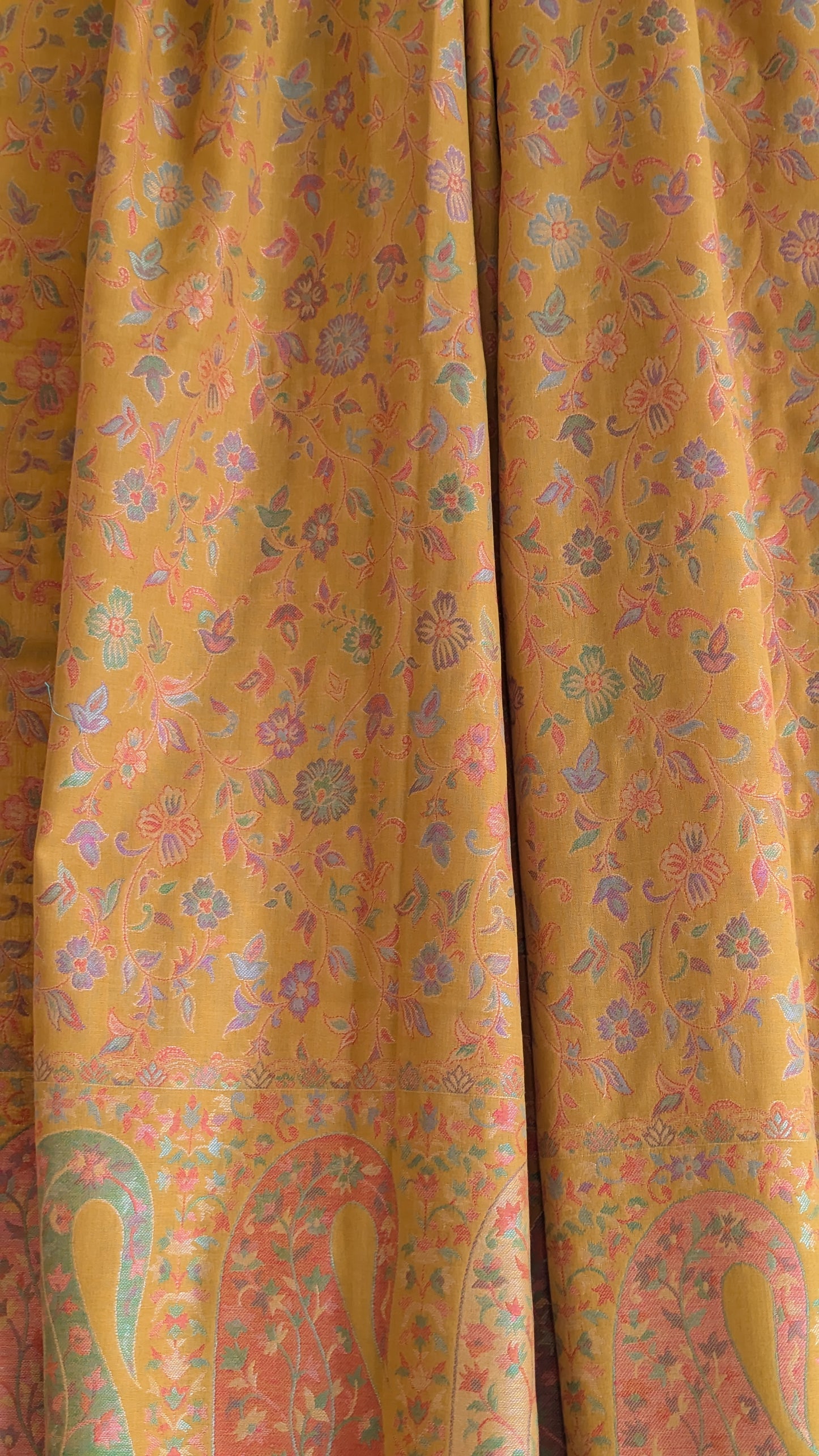 A mustard yellow lohi with multicolor patterns displayed.