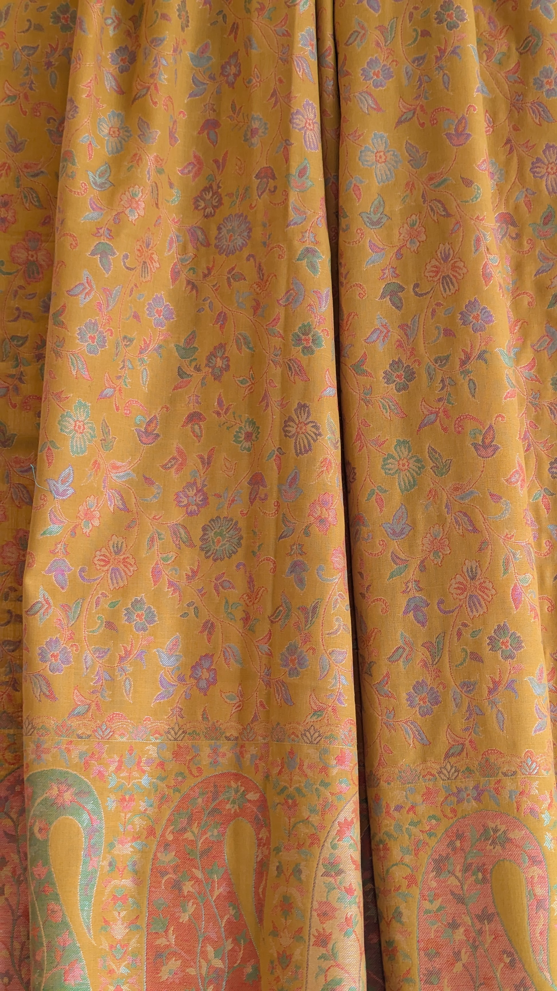 A mustard yellow lohi with multicolor patterns displayed.