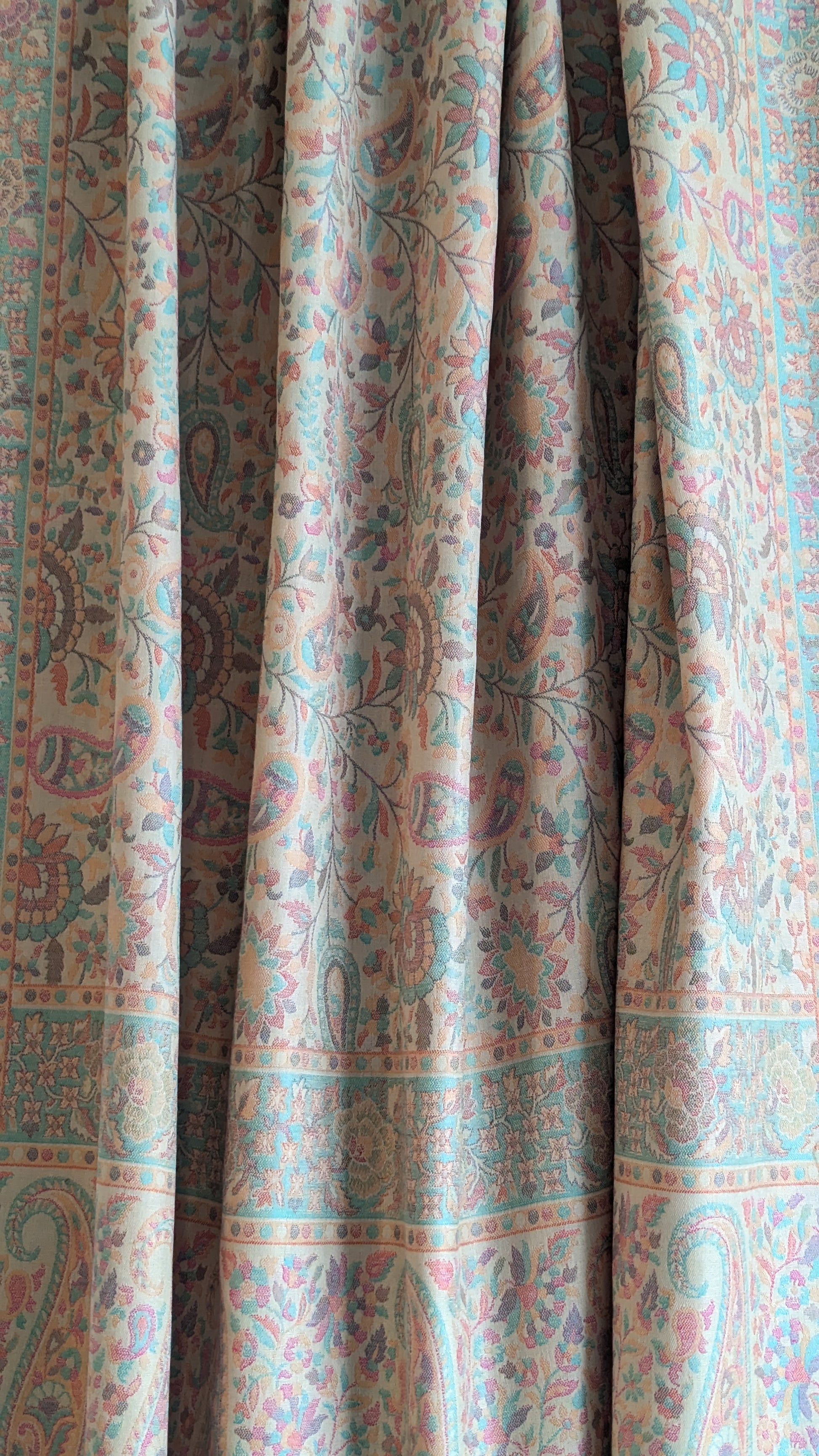 A beige lohi with multicolor patterns displayed.