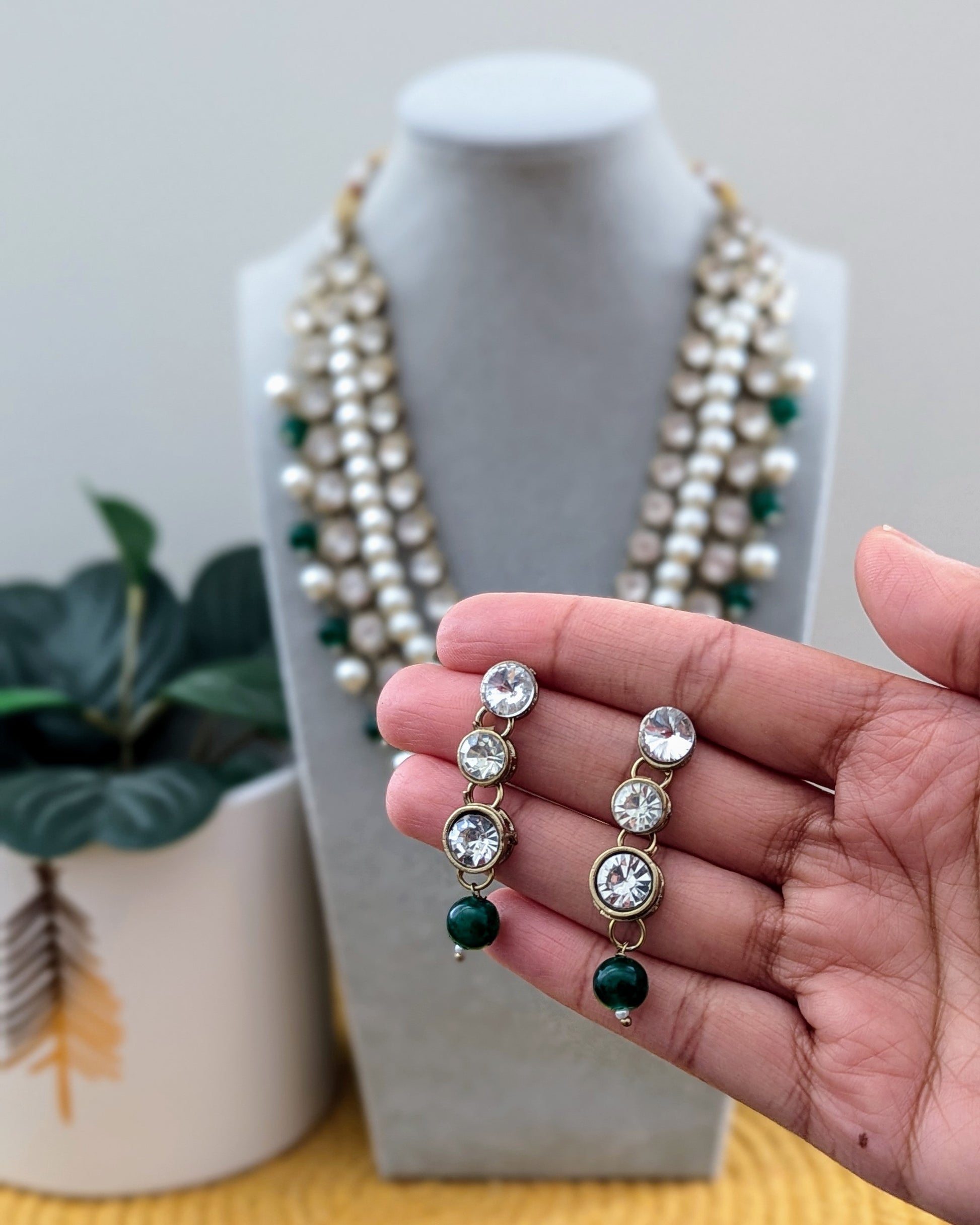 A pearl white Kundan necklace with multiple layers and green-tone metal beads displayed on a mannequin bust. Imitation jewelry. Pick-up in Ajax Ontario. Worldwide shipping available. Perfect for weddings, festival jewelry, indian Jewelry, kids jewelry, kundan jewelry, gifting, costume jewelry, fashion jewelry, Eid, onam, Diwali, karwachauth, navratri. Free shipping available. Jewelry for women. Indian jewelry in durham Toronto