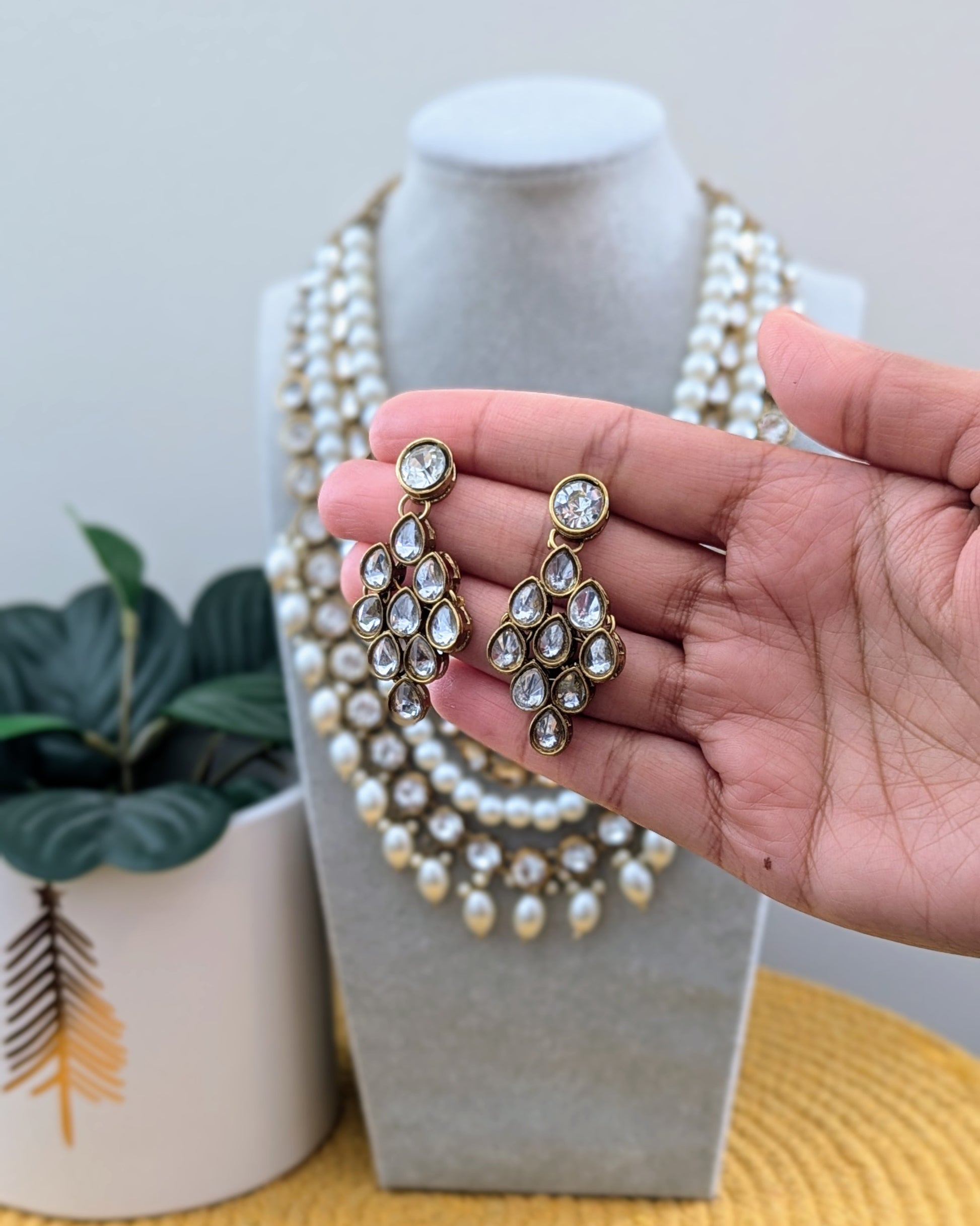 A pearl white Kundan necklace with multiple layers and gold-tone metal beads displayed on a mannequin bust. Imitation jewelry. Pick-up in Ajax Ontario. Worldwide shipping available. Perfect for weddings, festival jewelry, indian Jewelry, kids jewelry, kundan jewelry, gifting, costume jewelry, fashion jewelry, Eid, onam, Diwali, karwachauth, navratri. Free shipping available. Jewelry for women. Indian jewelry in durham Toronto