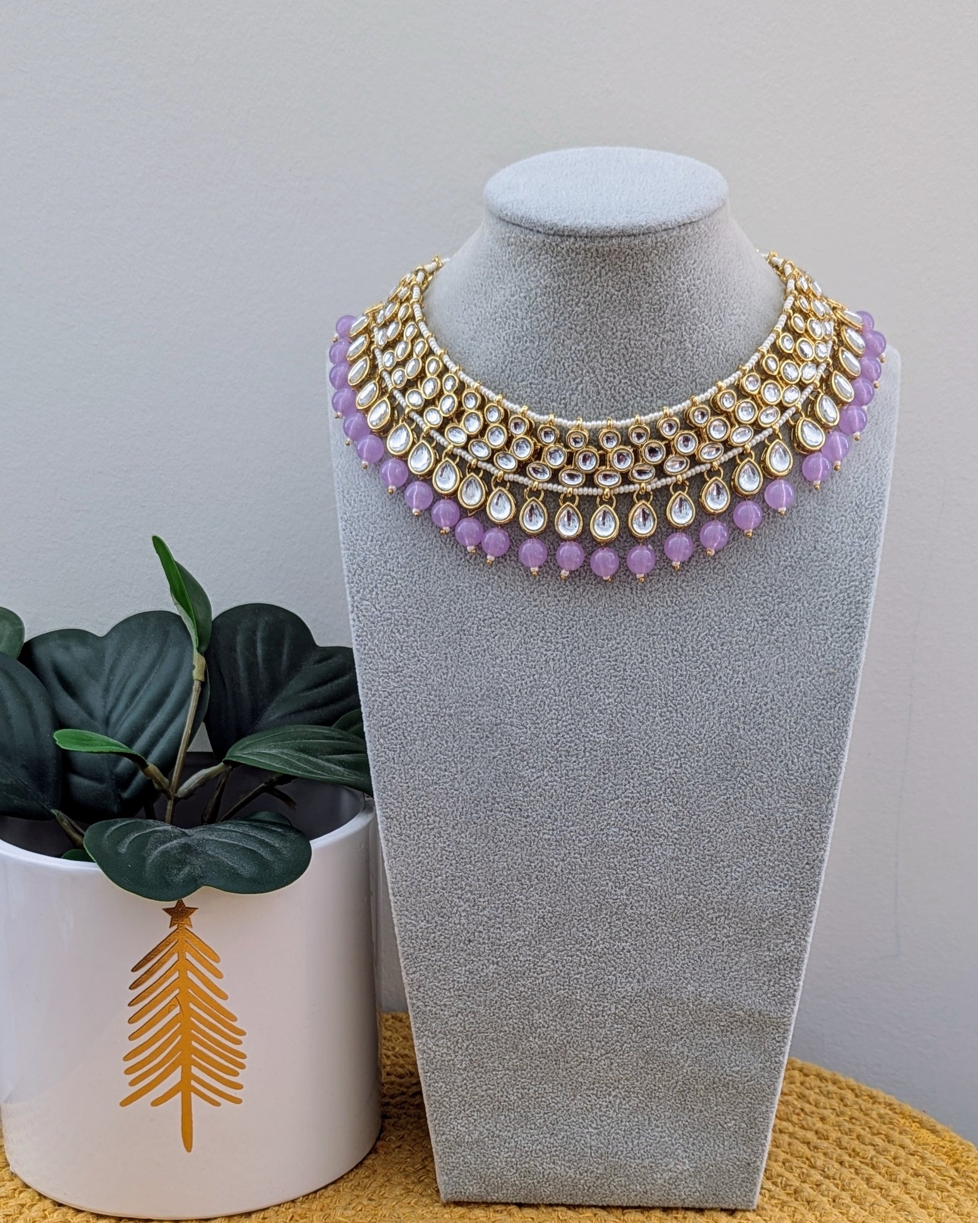 A lavender and gold choker necklace with pearl details displayed on a mannequin bust. Pick-up in Ajax Ontario. Worldwide shipping available. Perfect for weddings, festival jewelry, indian Jewelry, kids jewelry, kundan jewelry, gifting, costume jewelry, fashion jewelry, Eid, onam, Diwali, karwachauth, navratri. Free shipping available. Jewelry for women. Indian jewelry in durham Toronto canada.