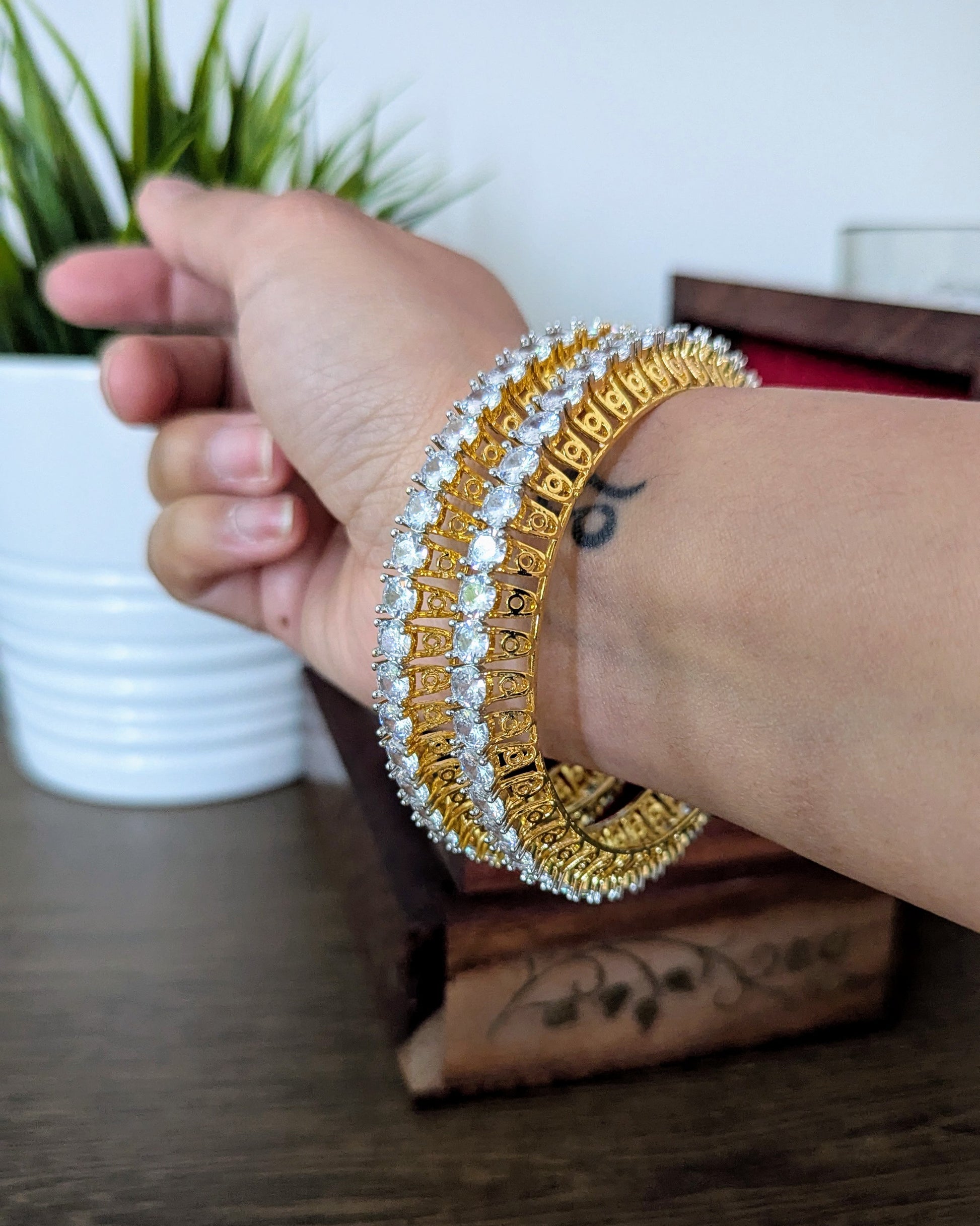 Gold bangles with diamond accents in a wooden box on a wooden surface. Imitation jewelry. Pick-up in Ajax Ontario. Worldwide shipping available. Perfect for weddings, festival jewelry, indian Jewelry, kids jewelry, kundan jewelry, gifting, costume jewelry, fashion jewelry, Eid, onam, Diwali, karwachauth, navratri. Free shipping available. Jewelry for women. Indian jewelry in ajax durham region. Bollywood style jewelry.