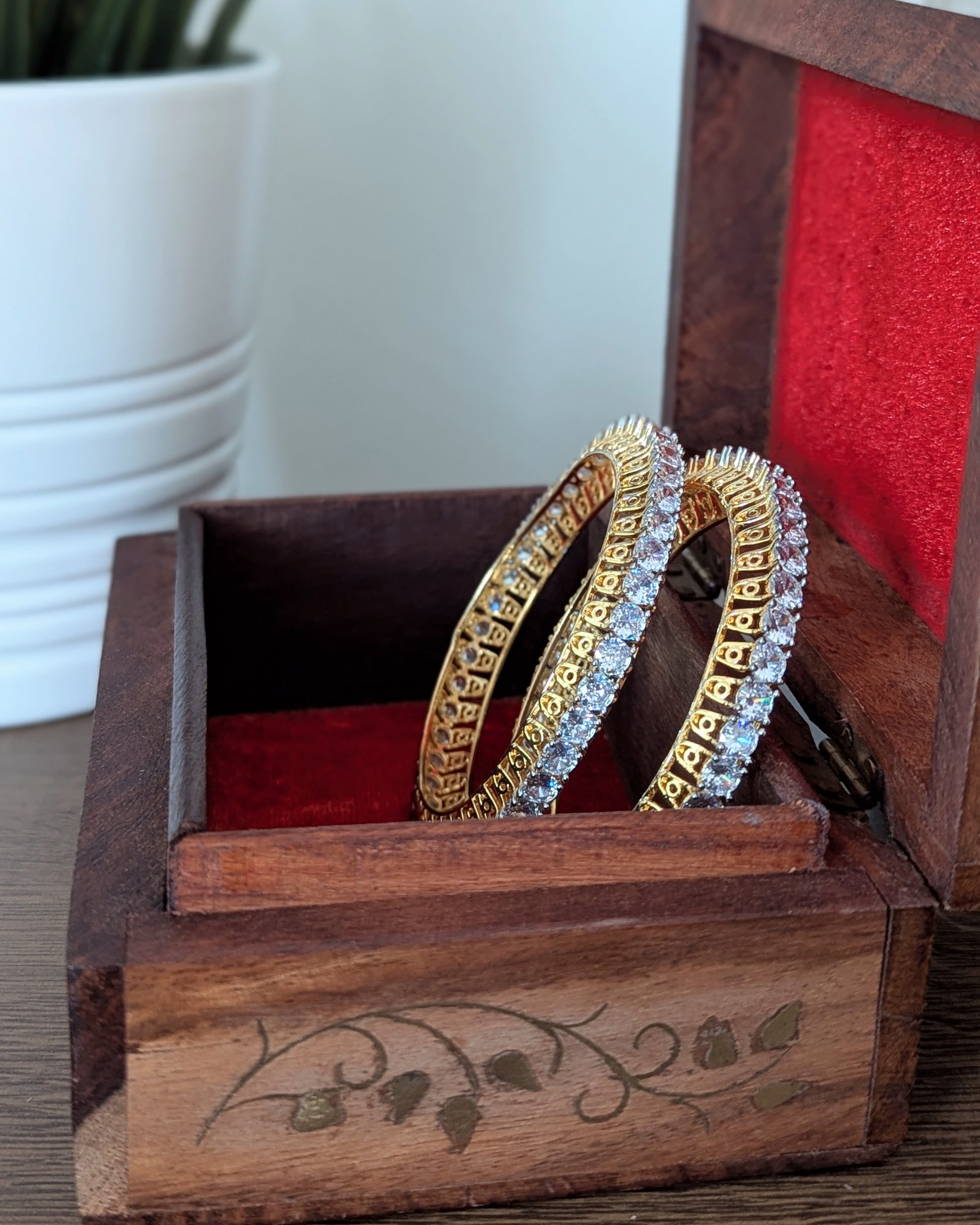 Gold bangles with diamond accents in a wooden box on a wooden surface. Imitation jewelry. Pick-up in Ajax Ontario. Worldwide shipping available. Perfect for weddings, festival jewelry, indian Jewelry, kids jewelry, kundan jewelry, gifting, costume jewelry, fashion jewelry, Eid, onam, Diwali, karwachauth, navratri. Free shipping available. Jewelry for women. Indian jewelry in ajax durham region. Bollywood style jewelry.