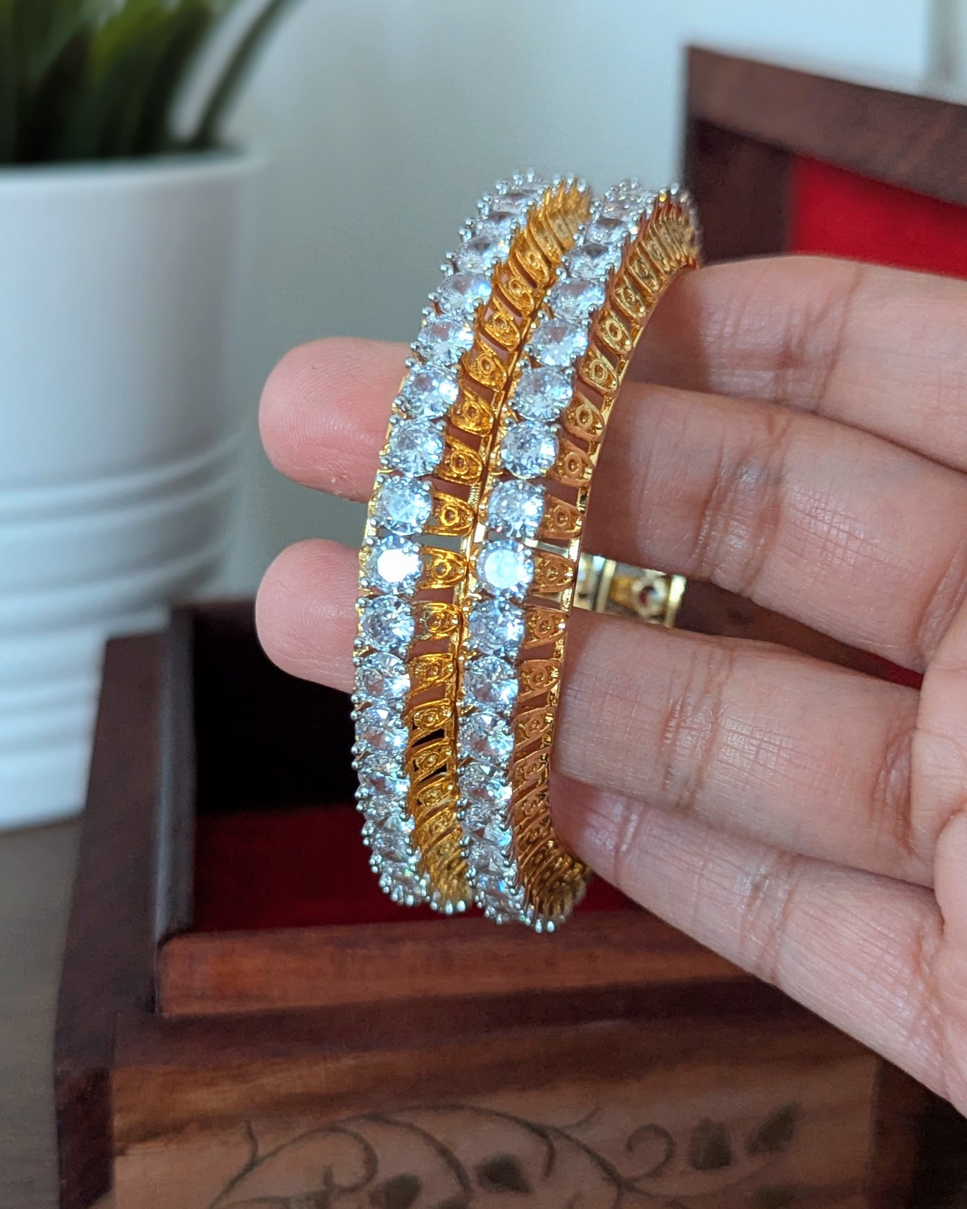 Gold bangles with diamond accents in a wooden box on a wooden surface. Imitation jewelry. Pick-up in Ajax Ontario. Worldwide shipping available. Perfect for weddings, festival jewelry, indian Jewelry, kids jewelry, kundan jewelry, gifting, costume jewelry, fashion jewelry, Eid, onam, Diwali, karwachauth, navratri. Free shipping available. Jewelry for women. Indian jewelry in ajax durham region. Bollywood style jewelry.