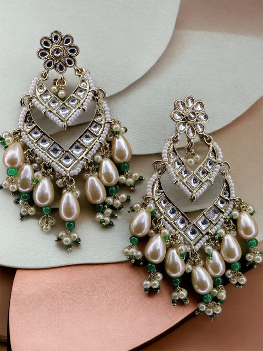Statement kundan midsized earrings with Pearl drop and green detail.