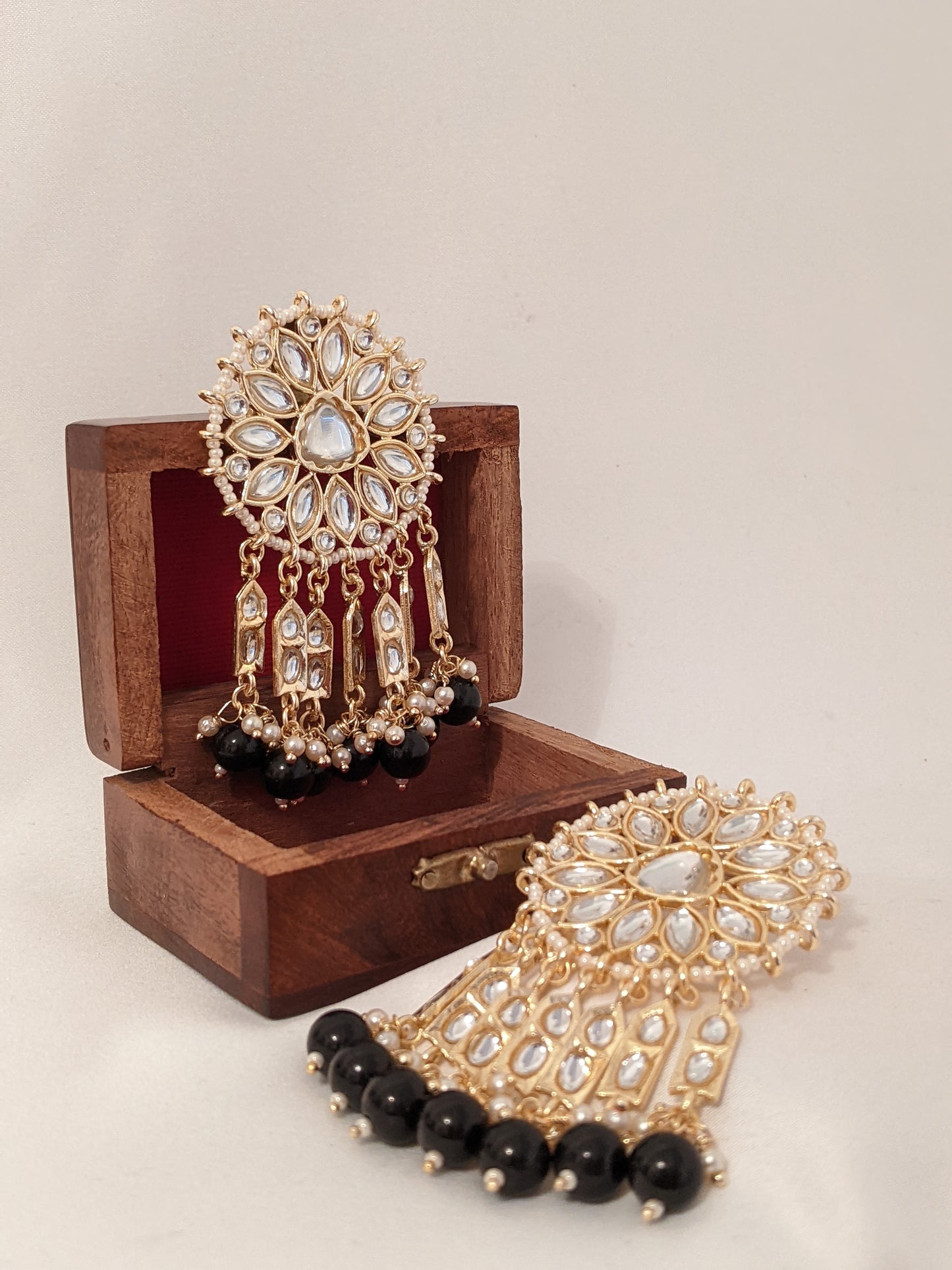 These beautiful earrings speak for themselves. Meticulously handcrafted in Kundan with dangling black pearl drops.