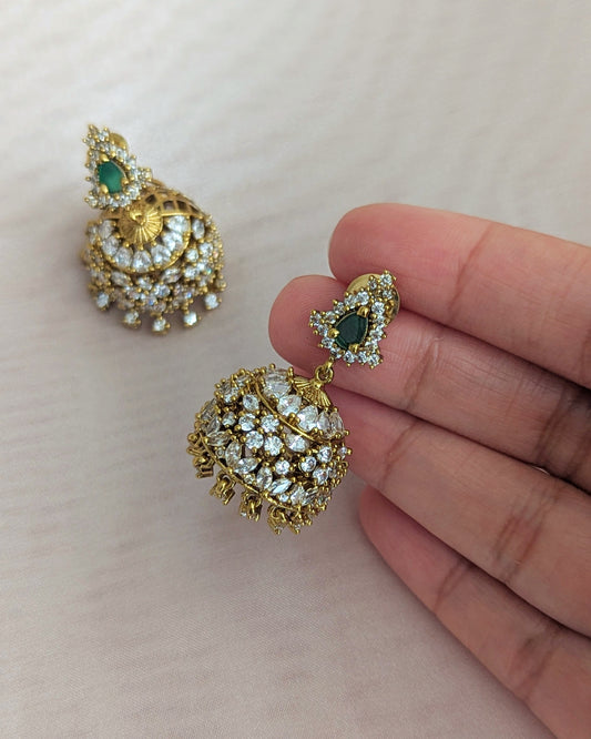 Gold and green gemstone earrings held by a hand on a light background looks like real gold. Pick-up in Ajax Ontario. Worldwide shipping available. Perfect for wedding, festival jewelry, indian Jewelry, kids jewelry, kundan jewelry, gifting, costume jewelry, fashion jewelry, Eid, onam, Diwali, karwachauth, navratri. Free shipping available. Jewelry for women. Indian jewelry in ajax durham region. Bollywood style jewelry.