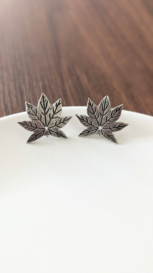 A pair of oxidized silver stud earrings designed to resemble maple leaves. Pick-up in Ajax Ontario. Worldwide shipping available. Perfect for wedding, festival jewelry, indian Jewelry, kids jewelry, kundan jewelry, gifting, costume jewelry, fashion jewelry, Eid, onam, Diwali, karwachauth, navratri. Free shipping available. Jewelry for women. Indian jewelry in ajax durham region.