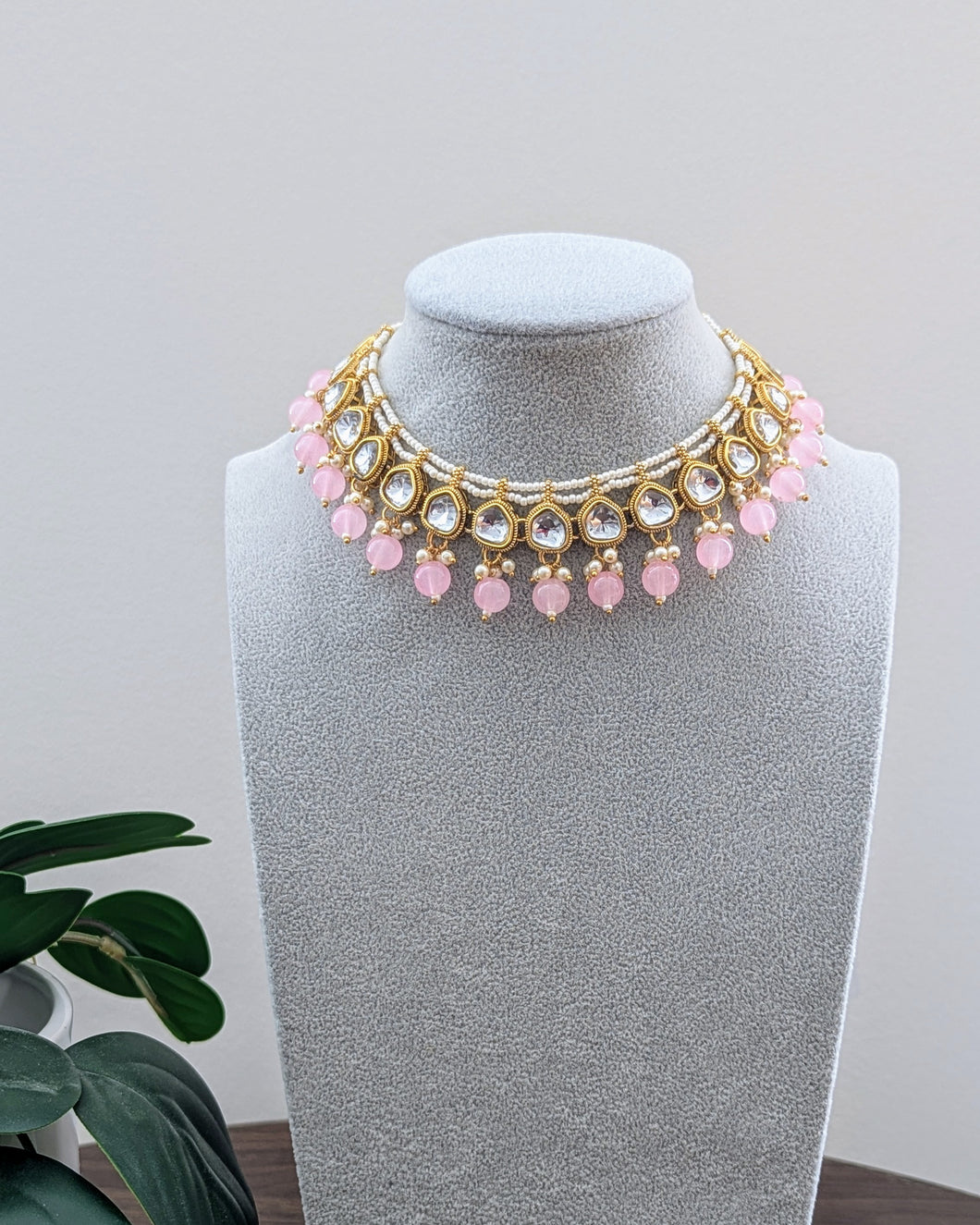 Beautiful small sized necklace in pink/baby pink with kundan design and small pearls. Comes with matching pink earrings and a tikka. Available at Sufna Canada in Ajax, Durham