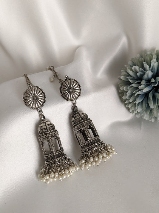 A woman wearing a silver and pearl earring with a geometric temple design and a detachable silver pearl ear chain. Pick-up in Ajax Ontario. Worldwide shipping available. Perfect for wedding, festival jewelry, indian Jewelry, kids jewelry, kundan jewelry, gifting, costume jewelry, fashion jewelry, Eid, onam, Diwali, karwachauth, navratri. Free shipping available. Jewelry for women. Indian jewelry in ajax durham region.