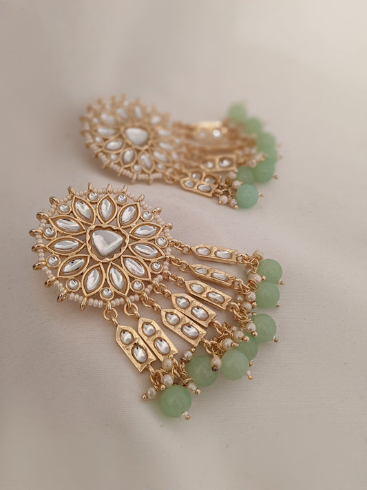 These beautiful earrings speak for themselves. Meticulously handcrafted in Kundan with dangling green pearl drops.