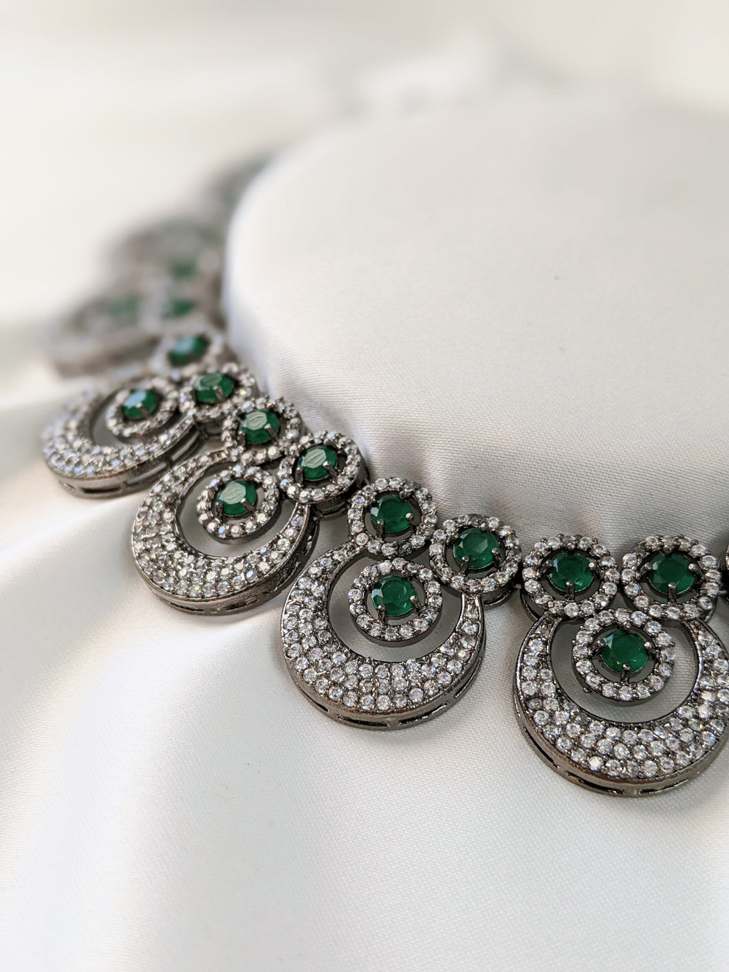Very elegant American Diamond necklace with green Emerald look-alike statement stones. Set in black metal base, this necklace is sheer elegance!