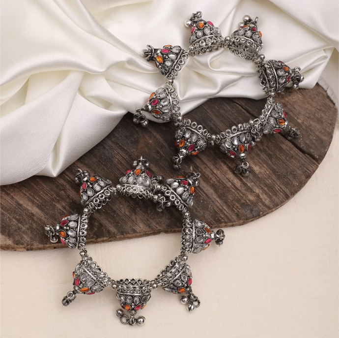 Bring a vibrant and unique look to any outfit with this oxidized silver Banjara Bangle! Made with a touch of dazzling rose pink stones, this bangle is sure to add a fun and eye-catching pop to your outfit.